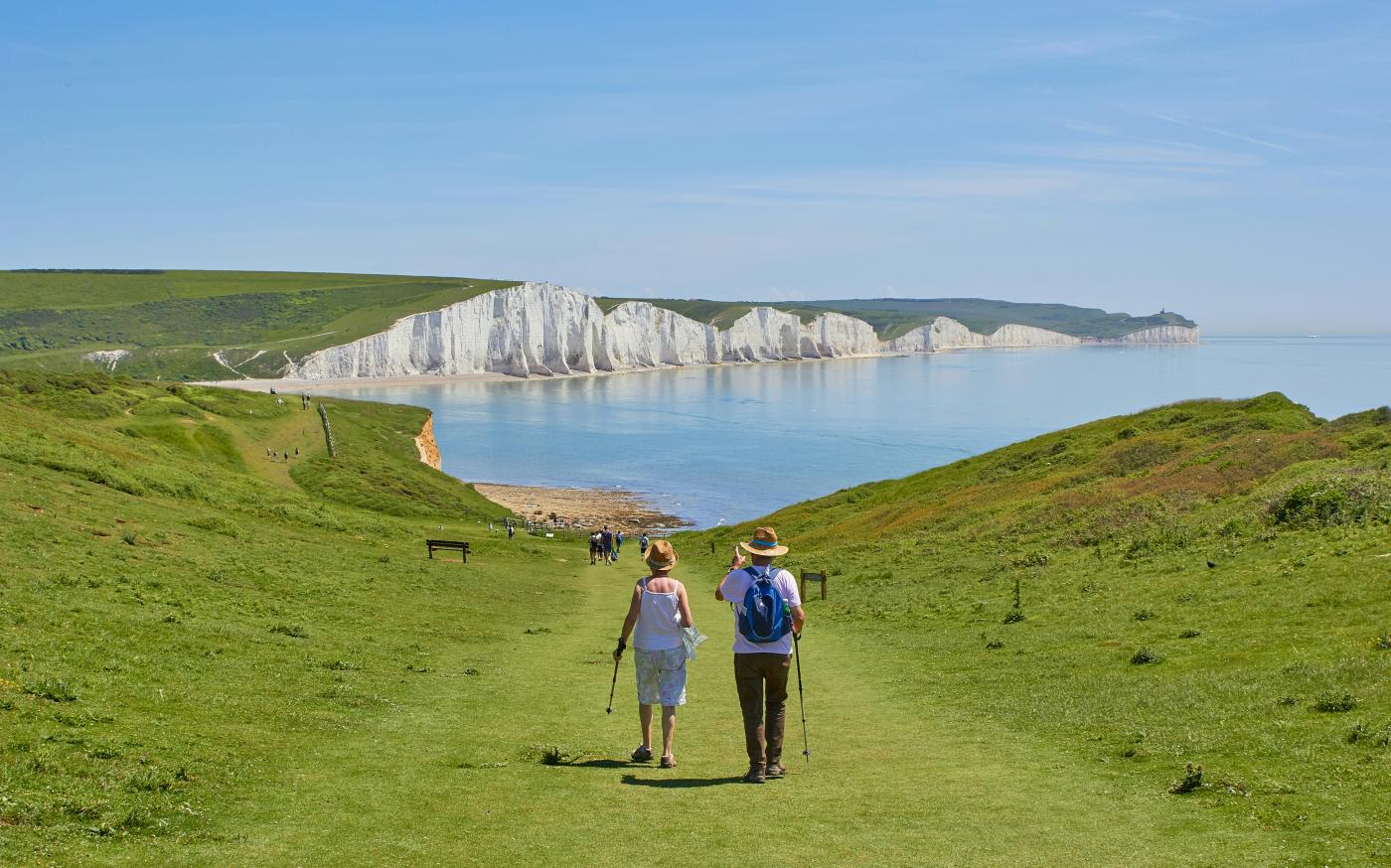2 men standing on green grass field near body of water during daytime by Marc Najera courtesy of Unsplash.